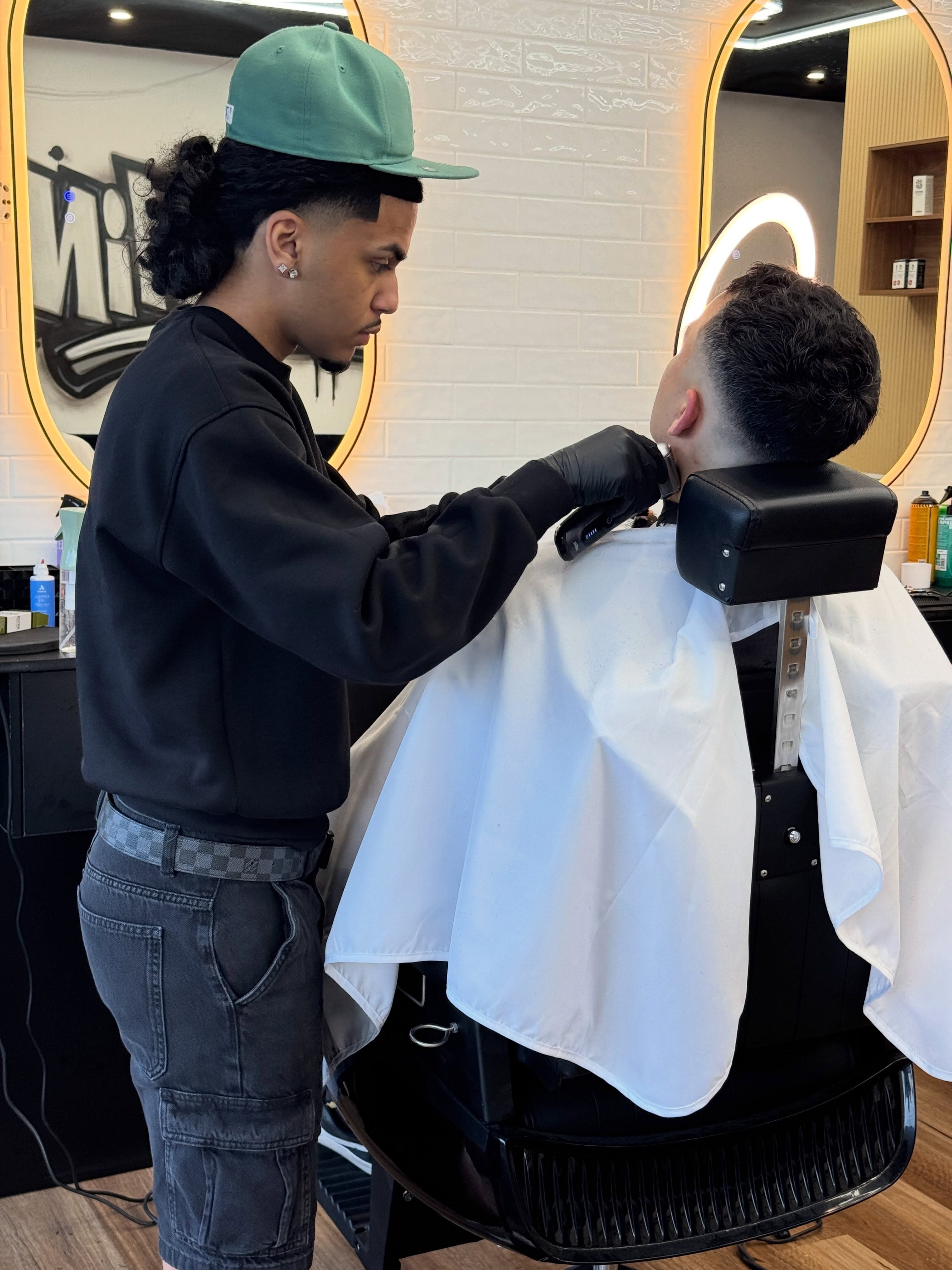 Barber shaping a fade, side profile